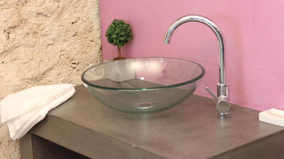 Mariage du béton ciré et de la pierre dans une salle de bain