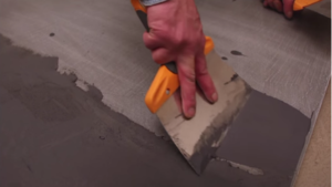 realiser-soi-meme-son-revetement-en-beton-cire-etape-numero-4-la-seconde-couche-de-beton-par-les-betons-de-clara-reseau-de-franchise-specialise-dans-le-revetement-en-beton-cire